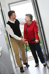 Man helping elderly woman with crutches